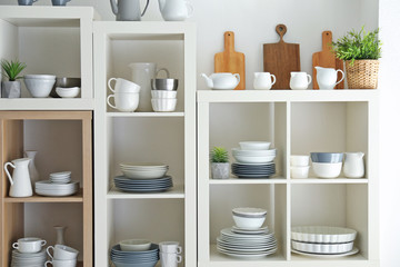 Fototapeta na wymiar Kitchen shelving with dishes on white wall background