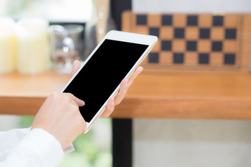 Closeup woman using tablet computer in the coffee shop, businesswoman sitting looking tablet is work at cafe, communication concept.