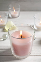 Fototapeta na wymiar Beautiful burning wax candle in glass on table