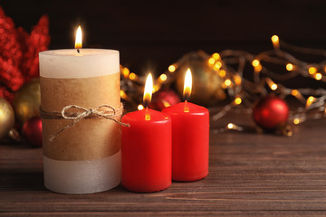 Beautiful composition with burning wax candles on table against blurred lights