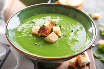 Bowl with delicious spinach soup on table
