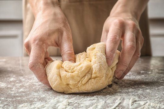 Woman kneading dough for pasta at table