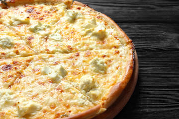 Tasty hot cheese pizza on wooden background