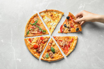 Woman taking slice of delicious pizza on light background, top view - obrazy, fototapety, plakaty