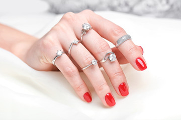 Woman wearing many different engagement rings, closeup