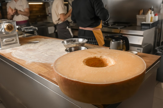 Big wheel of Parmesan cheese on counter of restaurant kitchen