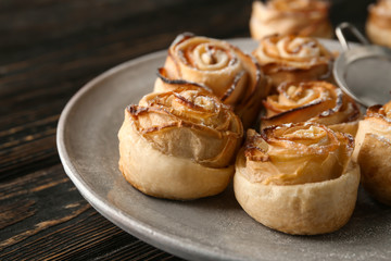 Plate with apple roses from puff pastry on table, closeup