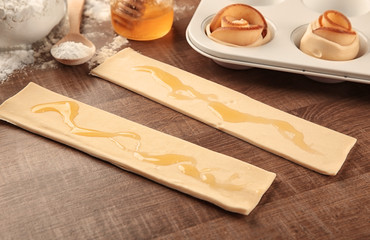 Raw pastry with honey on table