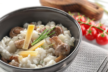 Bowl with risotto and mushrooms on table, closeup
