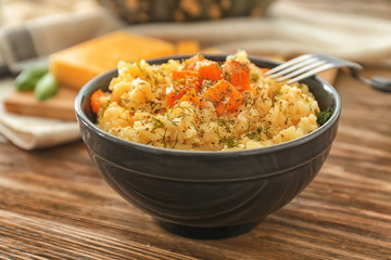 Bowl with delicious pumpkin risotto on wooden table