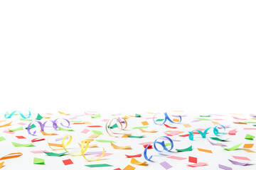 Colorful confetti and streamers on white background