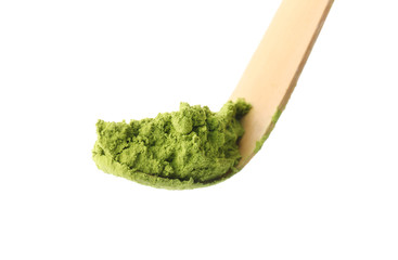 Matcha spoon with powdered green tea on white background