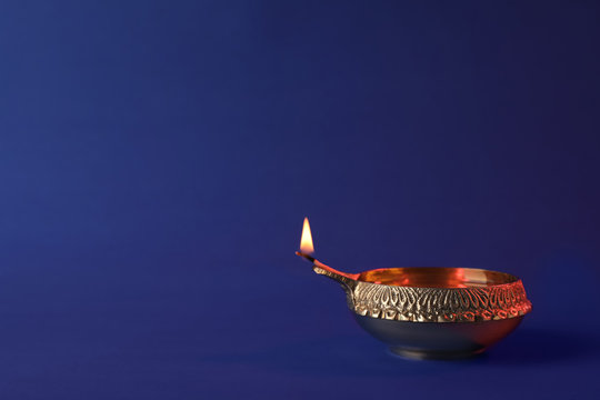 Diwali diya or clay lamp on color background