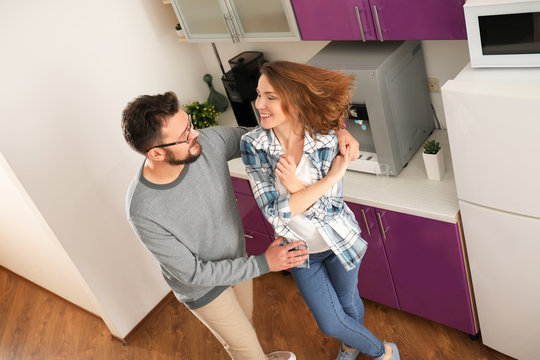 Lovely couple dancing together in kitchen