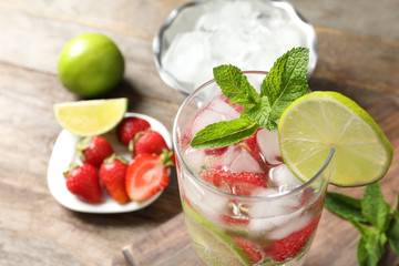 Glass of natural lemonade with lime, strawberries and mint on table, closeup