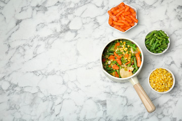 Flat lay composition with frozen vegetables on marble background