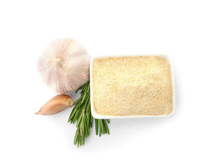 Bowl of dry garlic powder and rosemary on white background, top view
