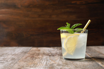 Natural lemonade with mint in glass on wooden table - obrazy, fototapety, plakaty