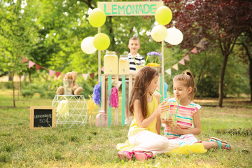 Little girls with natural lemonade in park