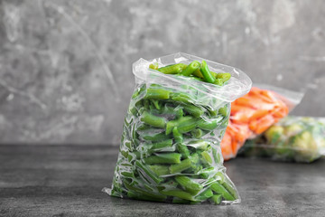Plastic bag with frozen green beans on table. Vegetable preservation