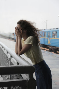 Depressed young woman at railway station