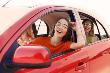 Happy beautiful young women together in car