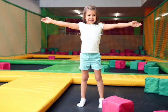 Cute girl jumping on trampoline in entertainment center