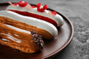 Various tasty eclairs on tray