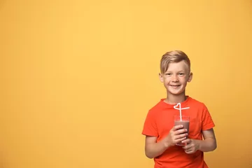 Papier Peint photo Milk-shake Little boy with glass of milk shake on color background