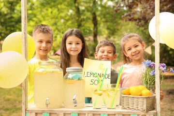 Little children at lemonade stand in park