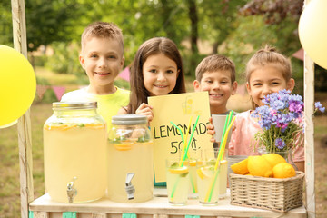 Little children at lemonade stand in park