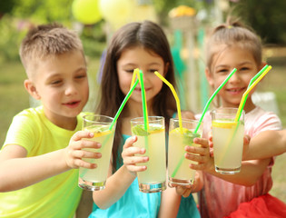 Little children with natural lemonade in park - obrazy, fototapety, plakaty