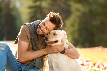 Cute yellow labrador retriever with owner outdoors