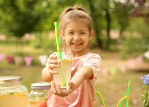 Little girl with natural lemonade in park