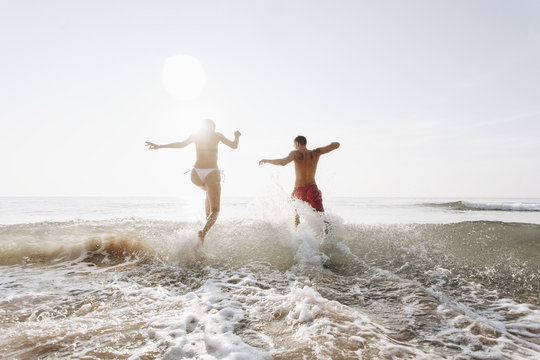 Happy Couple Running Into The Water