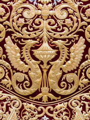 Fototapeta premium Detail of two dragons embroidered in gold on red velvet in the mantle of the Virgin of Regla, Holy Week in Seville, Spain