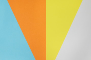 Paper variety. Blue, yellow, orange and white stacked on the floor. background