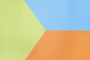 The blue, yellow, and orange paper is stacked on the floor. background