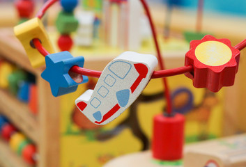 Wooden toy on rail in the shape of star, moon, and a plane for kids playing and practicing hand movement