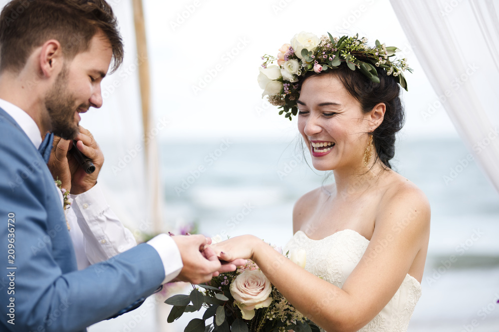 Wall mural young couple in a wedding ceremony at the beach