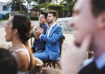 Guests attending a beach wedding ceremony