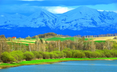 Fototapeta na wymiar 北海道、美瑛町の水沢ダムより見る十勝岳連峰の雪渓風景