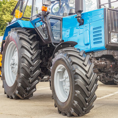 Tractor for farm work, modern agricultural transport working in the field, modern tractor close-up