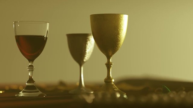 Medieval table. Goblets with red wine, jewellery, gold coins and precious stones