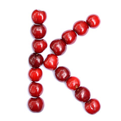 Letter K made with cherries to form a letter of the alphabet. Berry letters on a white background.