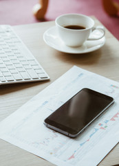 office working on office table with computer and tablet and graph chart and coffee  cup