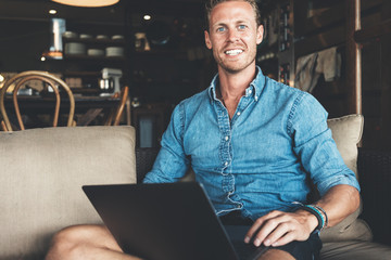 Portrait of entrepreneur working on his project at street cafe, using laptop