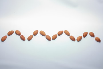 wavy line of nuts (almond) on white background