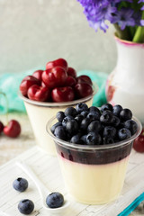 Italian dessert pana cota with berry jam and fresh blueberries