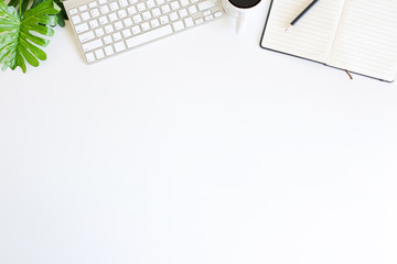 Top view workspace computer keyboard, and coffee cup on workspace white table.